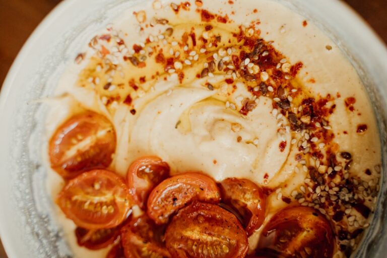 Delicious spiced hummus topped with roasted cherry tomatoes and sesame seeds.