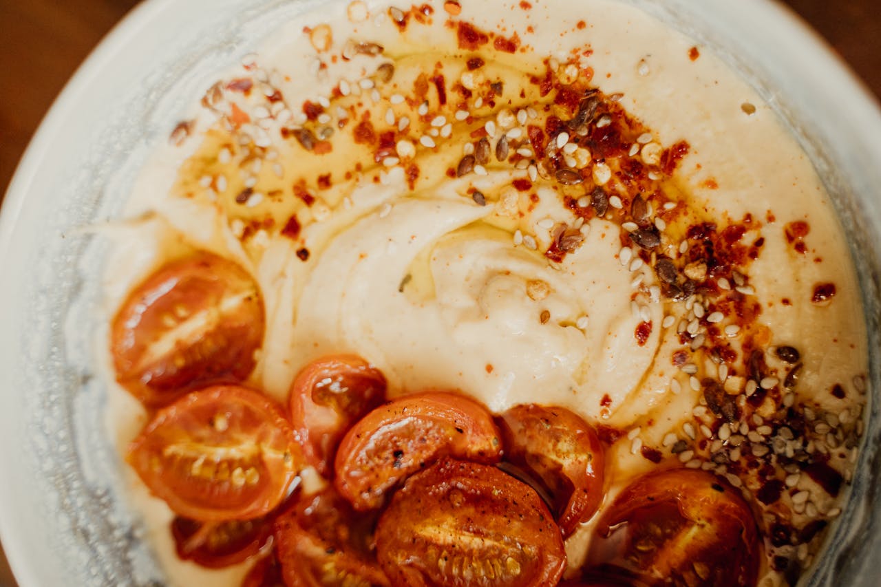 Delicious spiced hummus topped with roasted cherry tomatoes and sesame seeds.